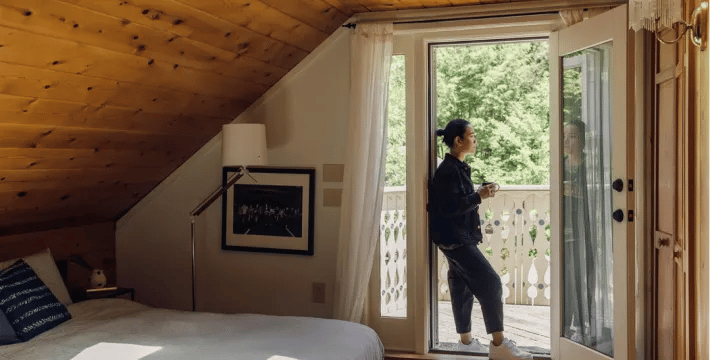 Woman standing in a doorway leading to a balcony